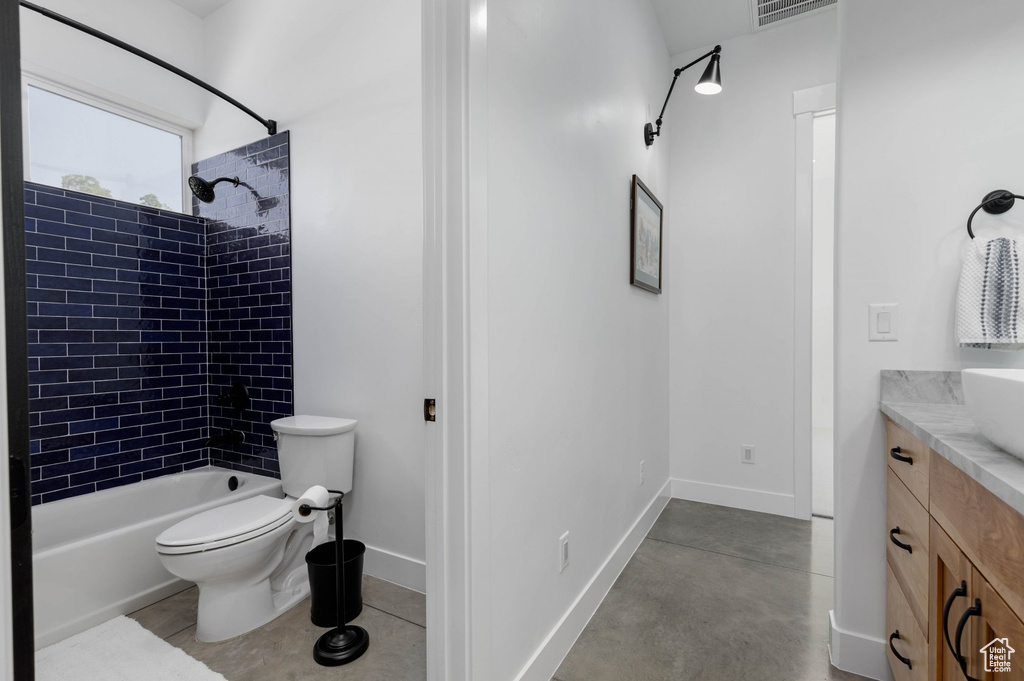 Full bathroom featuring vanity, tiled shower / bath, and toilet