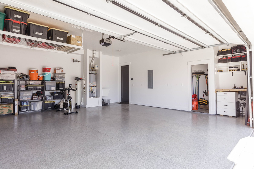 Garage with sink, electric panel, and a garage door opener