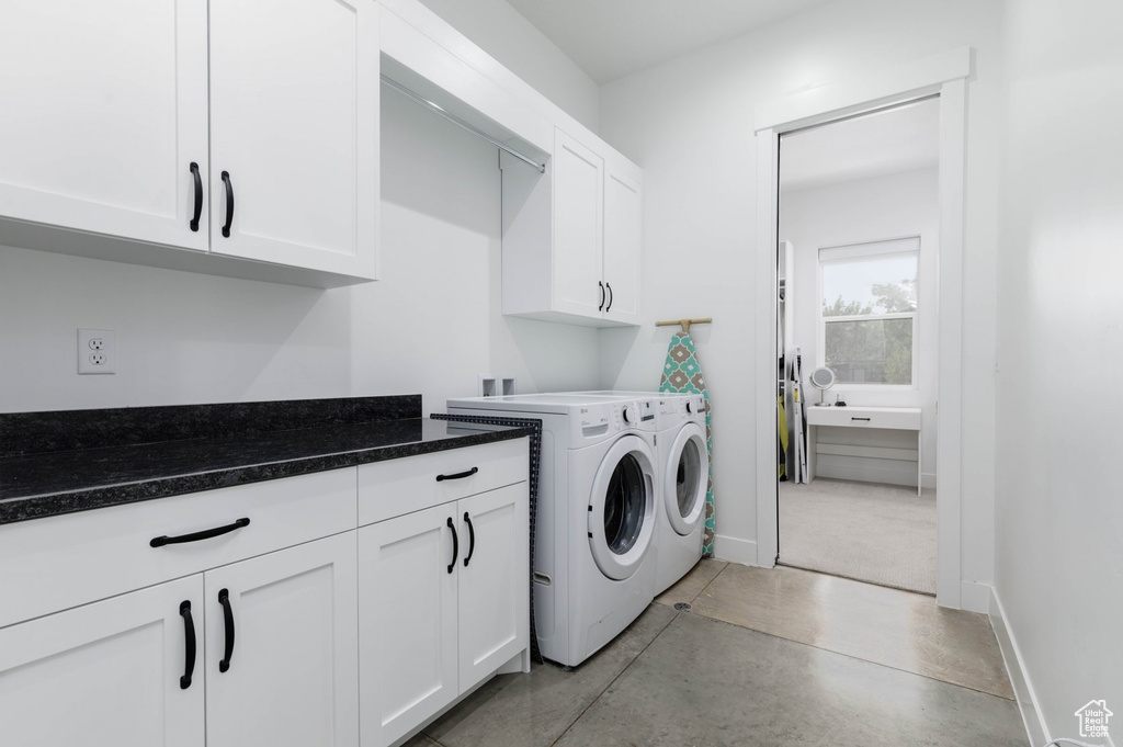 Washroom featuring cabinets and washer and dryer