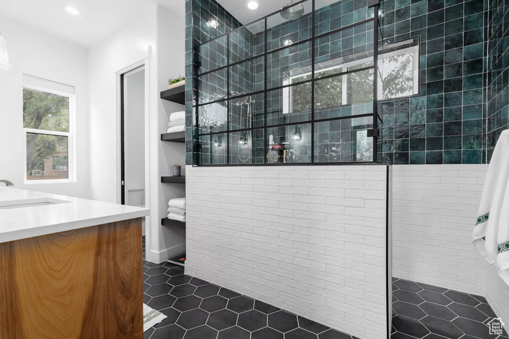 Bathroom featuring tile patterned flooring, vanity, and an enclosed shower