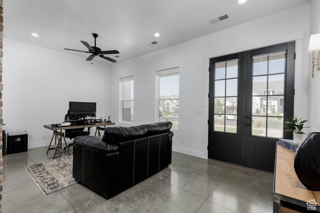 Tiled living room featuring french doors and ceiling fan