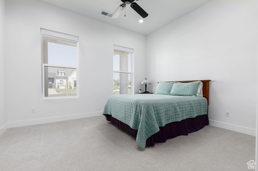 Bedroom with ceiling fan and light colored carpet