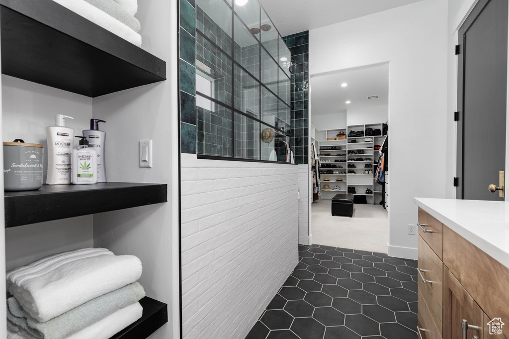 Bathroom featuring a shower, vanity, and tile patterned floors