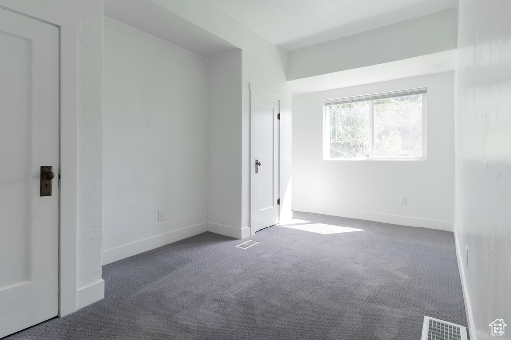 Unfurnished room featuring dark carpet