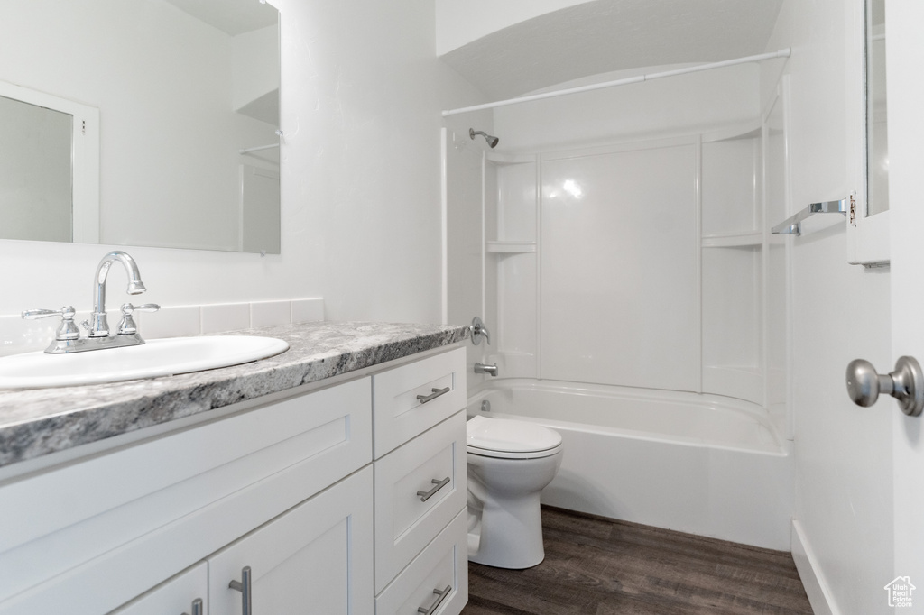 Full bathroom with shower / bathtub combination, toilet, vanity, and hardwood / wood-style floors