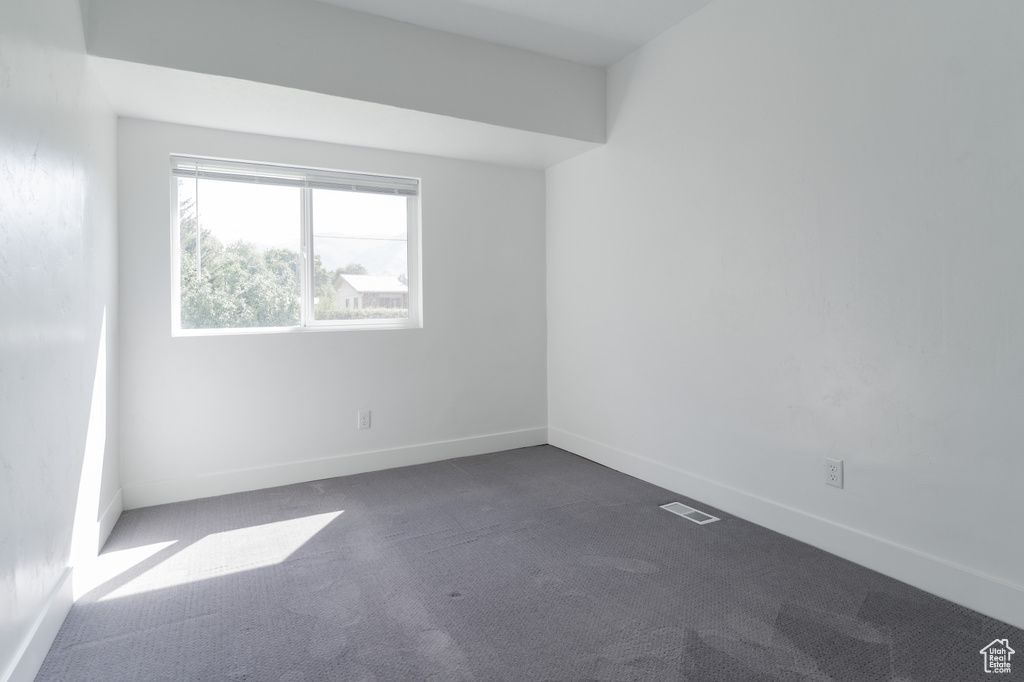 Unfurnished room featuring dark carpet