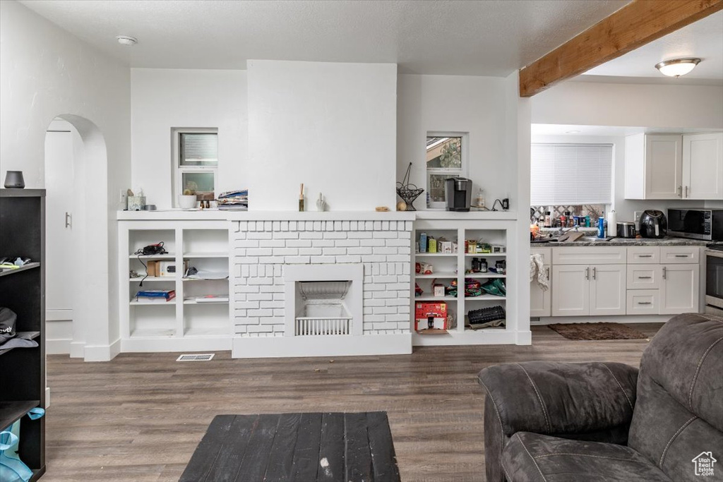 Living room featuring a fireplace, hardwood / wood-style flooring, and beam ceiling