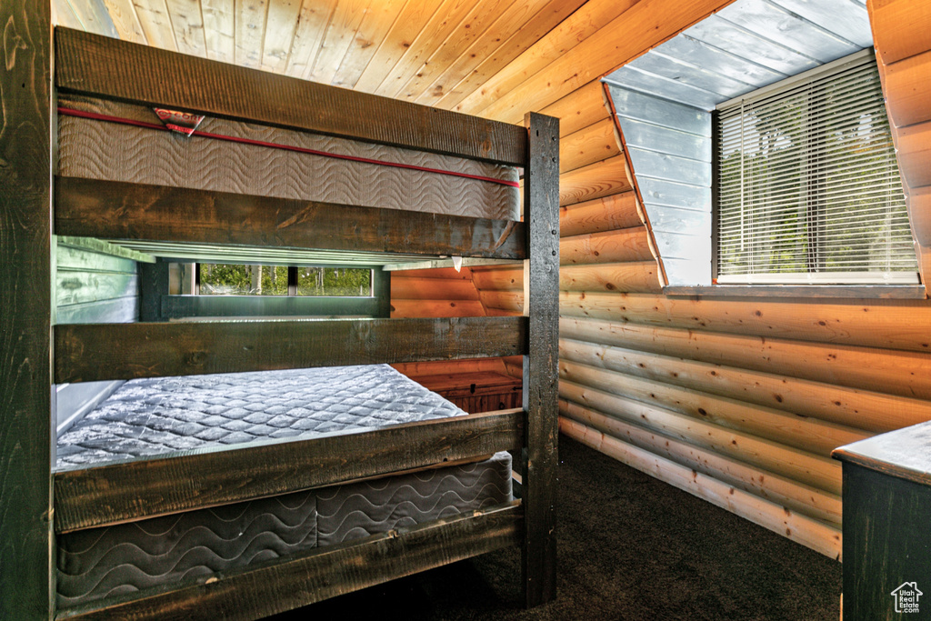 Bedroom featuring wood ceiling and rustic walls