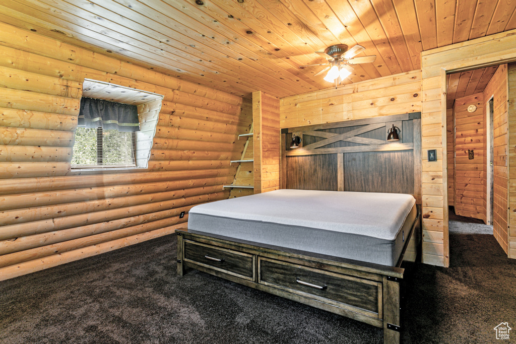 Carpeted bedroom featuring log walls and wooden ceiling