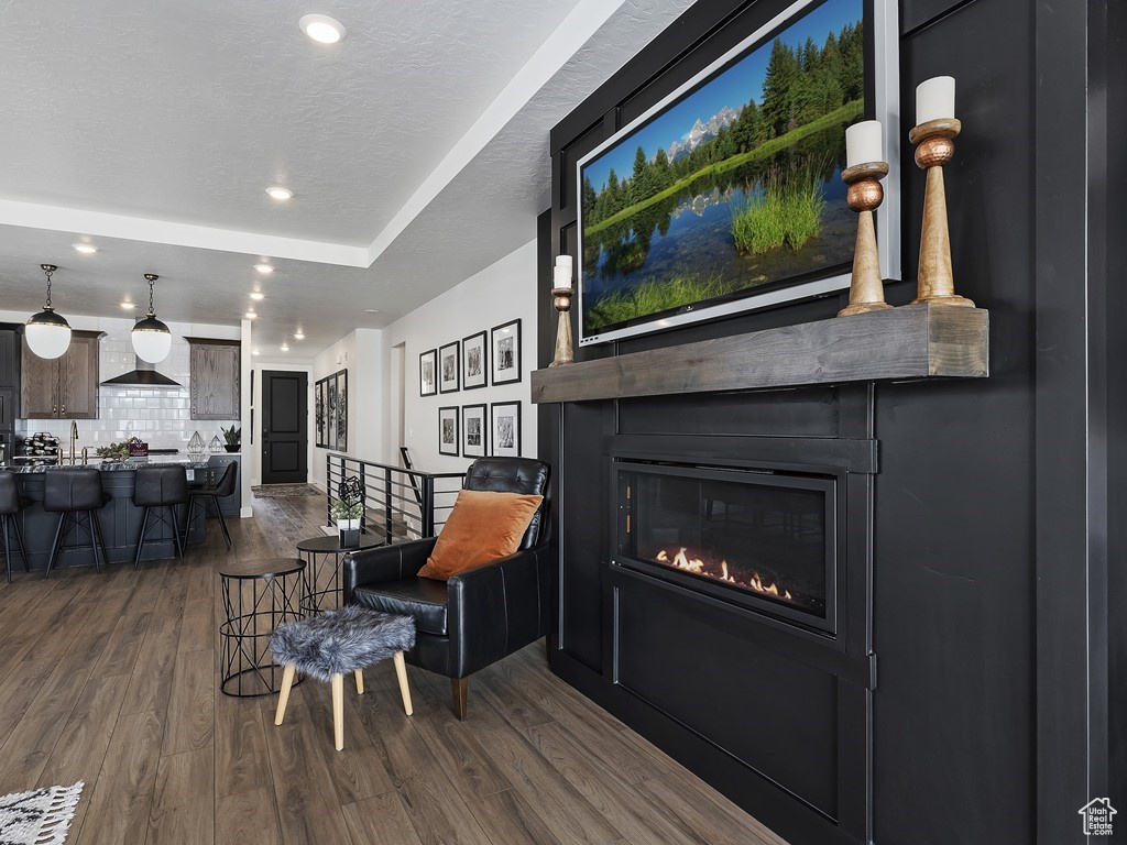 Living area featuring wood-type flooring and a raised ceiling