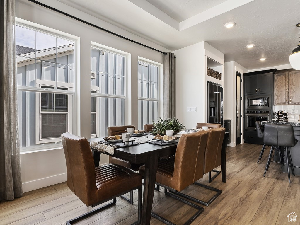 Dining room with hardwood / wood-style flooring and a raised ceiling