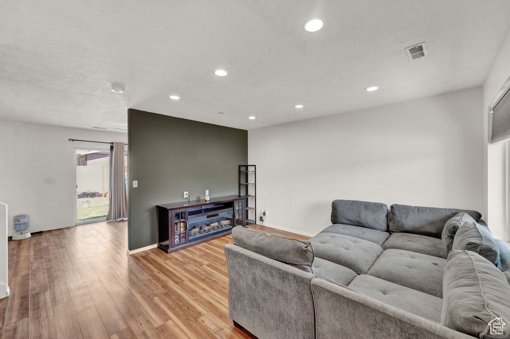 Living room with light hardwood / wood-style floors and a textured ceiling