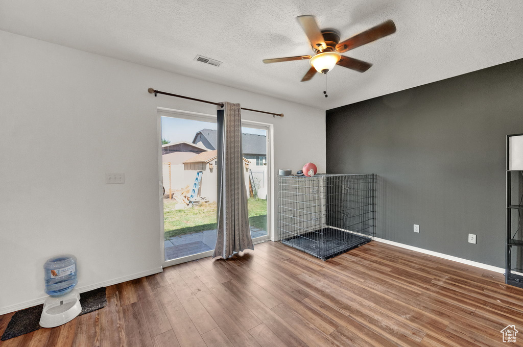 Unfurnished room with a textured ceiling, hardwood / wood-style floors, and ceiling fan