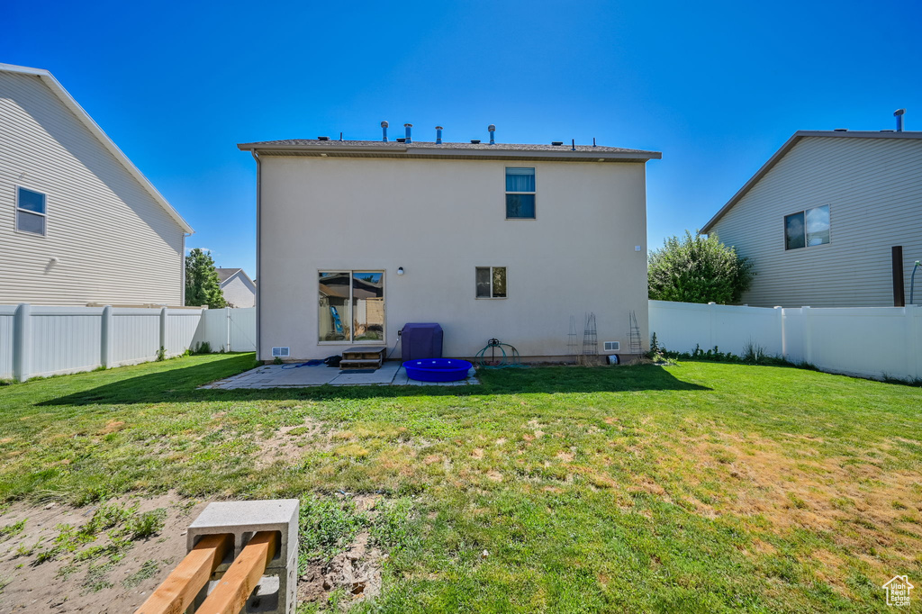 Rear view of property featuring a patio and a lawn