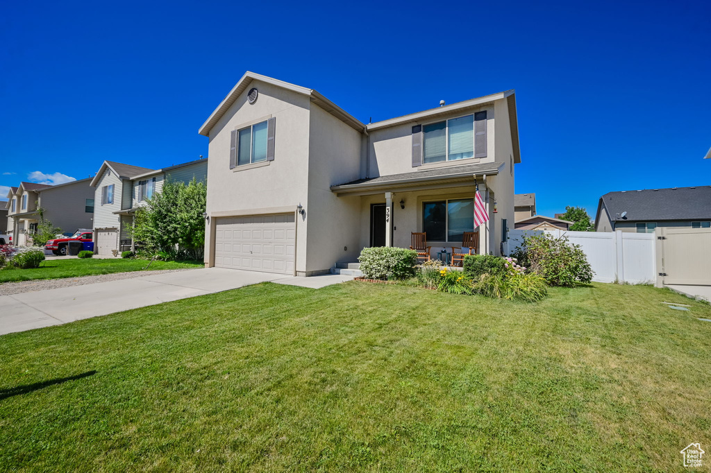 View of front of property featuring a garage and a front yard