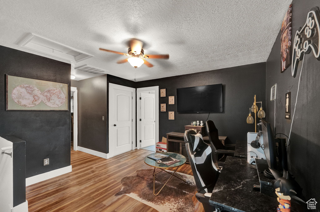 Interior space with hardwood / wood-style flooring, a textured ceiling, and ceiling fan