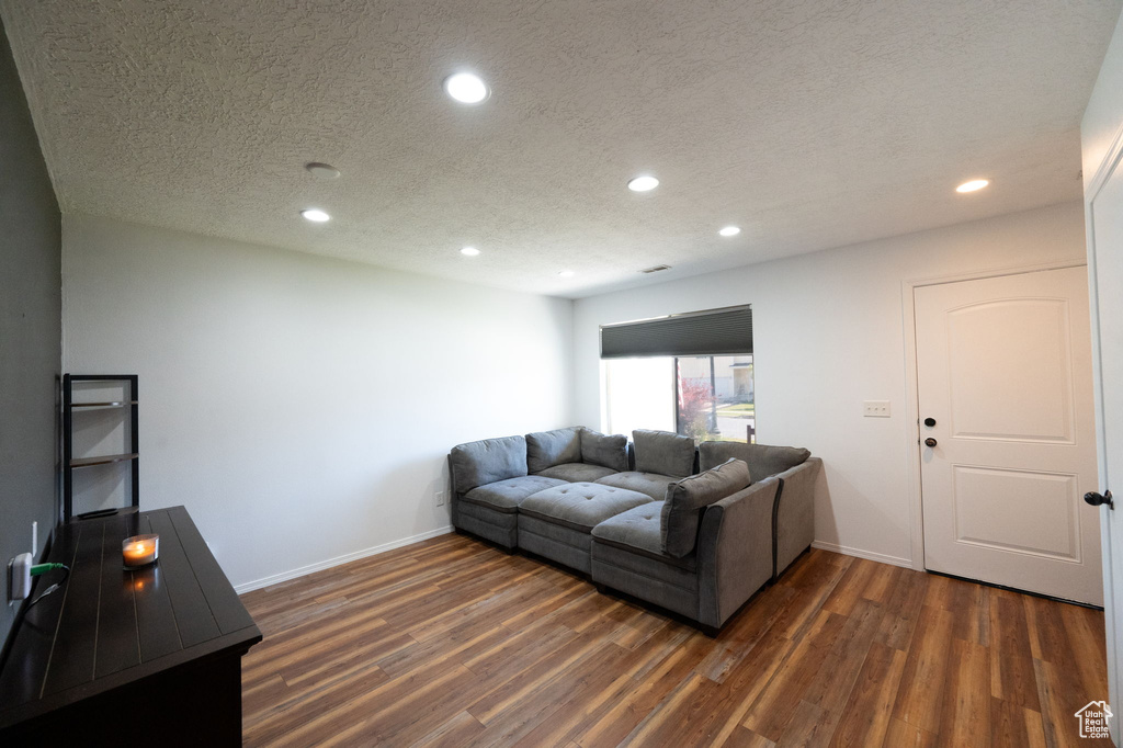 Living room with dark hardwood / wood-style flooring and a textured ceiling