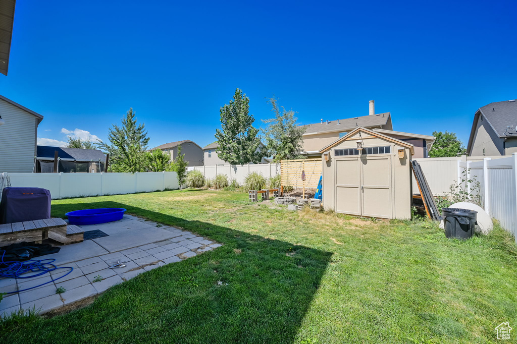 View of yard featuring a storage shed and a patio