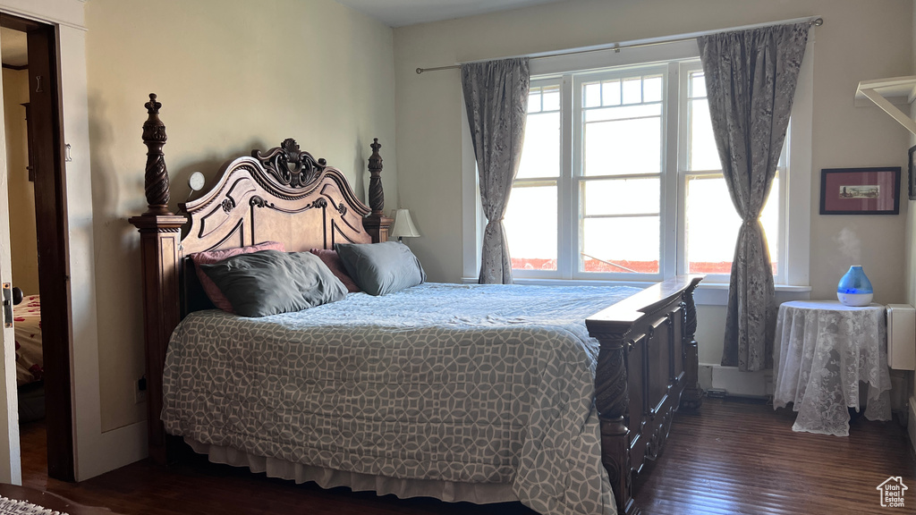 Bedroom featuring multiple windows and dark hardwood / wood-style floors