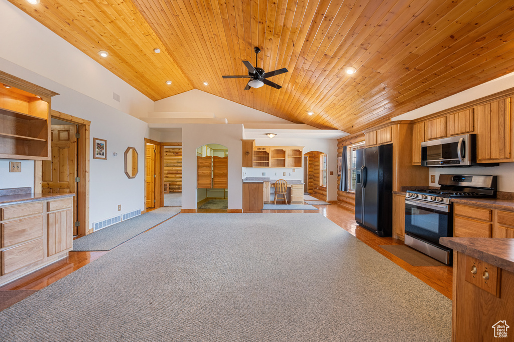 Kitchen with wood ceiling, light colored carpet, and appliances with stainless steel finishes