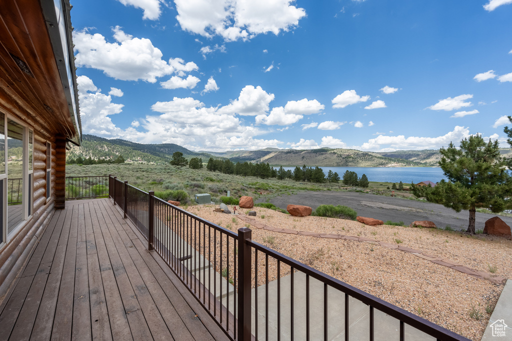 Wooden terrace featuring a water and mountain view