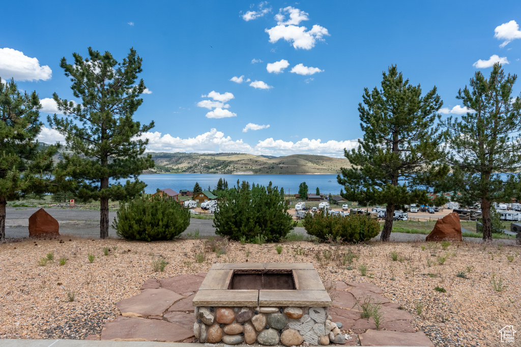 Exterior space featuring a water view and an outdoor fire pit