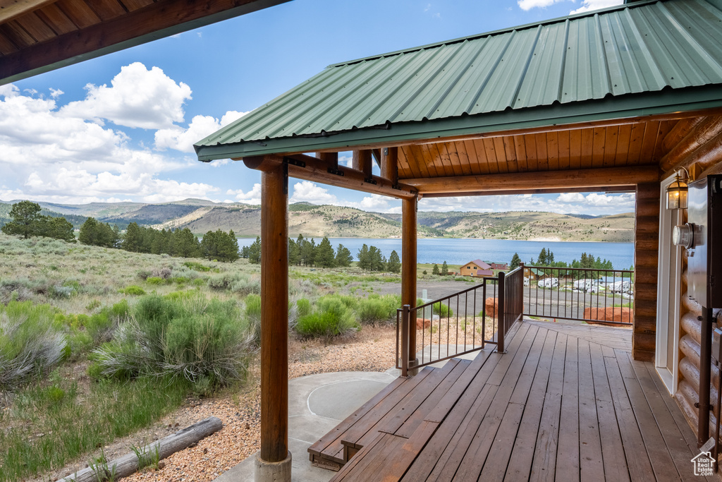 Wooden terrace featuring a water and mountain view