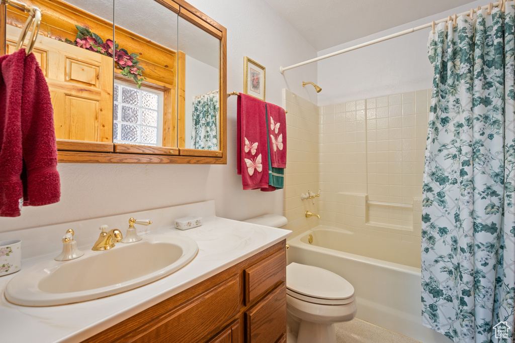 Full bathroom with vanity, toilet, and shower / bath combination with curtain