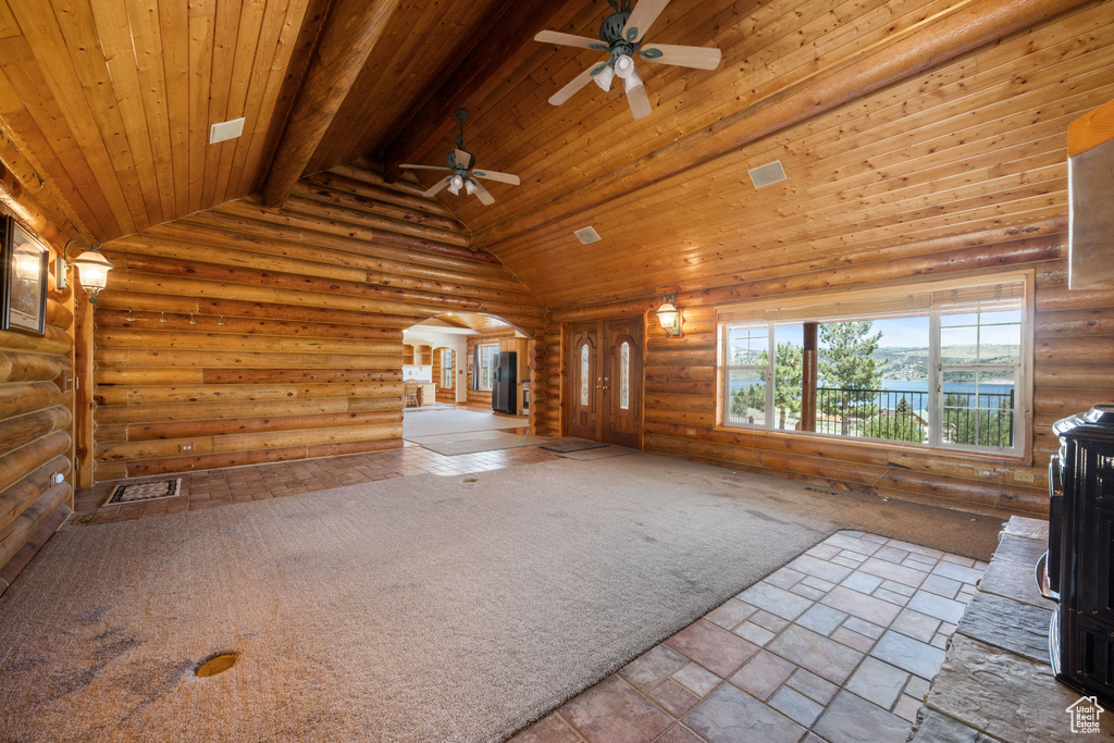 Interior space with wooden ceiling, tile patterned flooring, log walls, and ceiling fan