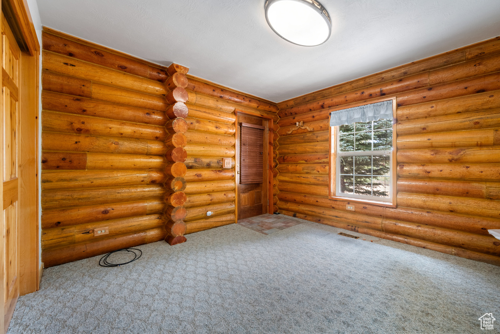 Carpeted empty room with rustic walls