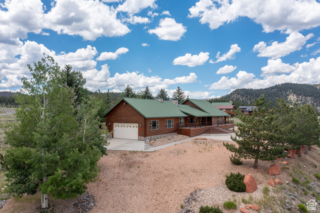 Log cabin with a garage and a mountain view