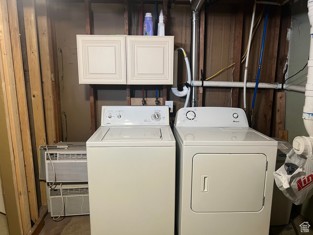 Laundry area with separate washer and dryer and cabinets