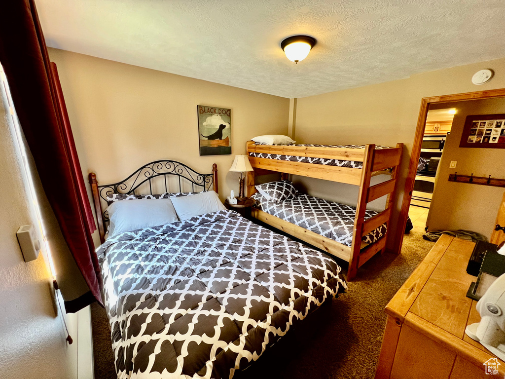 Carpeted bedroom featuring a textured ceiling