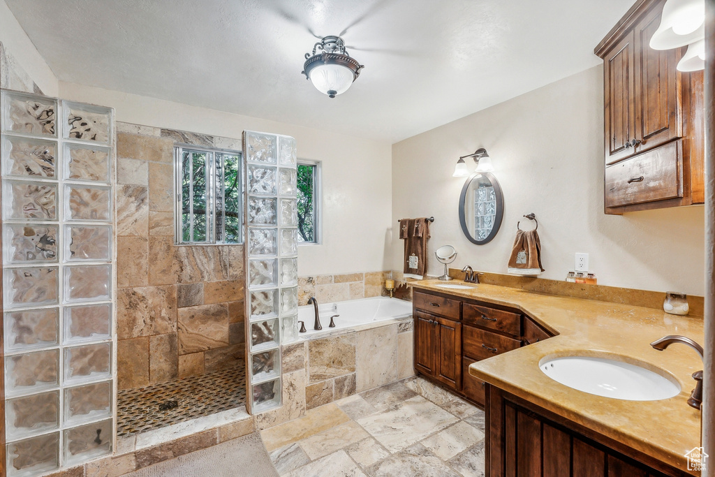 Bathroom featuring tile floors, independent shower and bath, and vanity