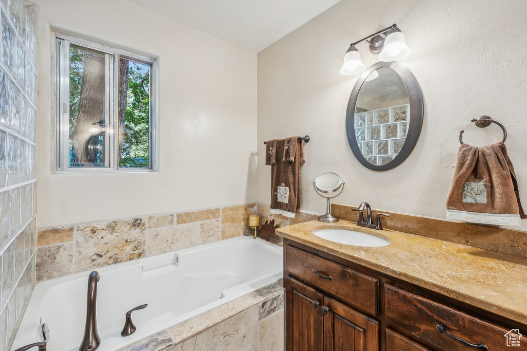 Bathroom with tiled bath and large vanity