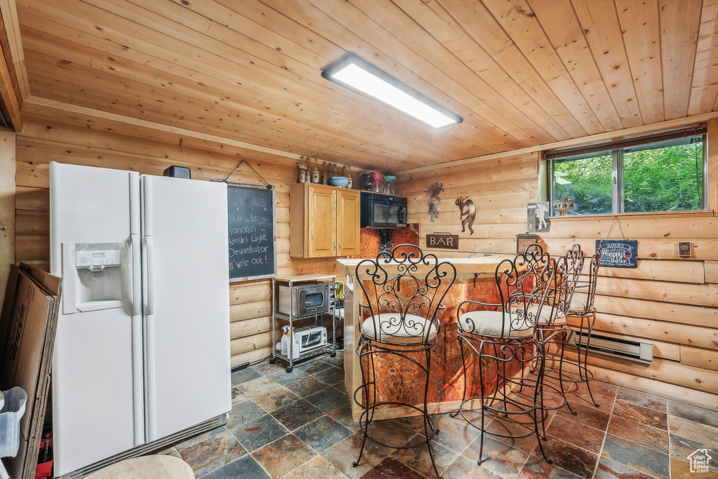 Kitchen featuring rustic walls, white fridge with ice dispenser, and wood ceiling