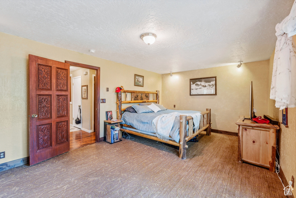 Bedroom featuring hardwood / wood-style floors and a textured ceiling