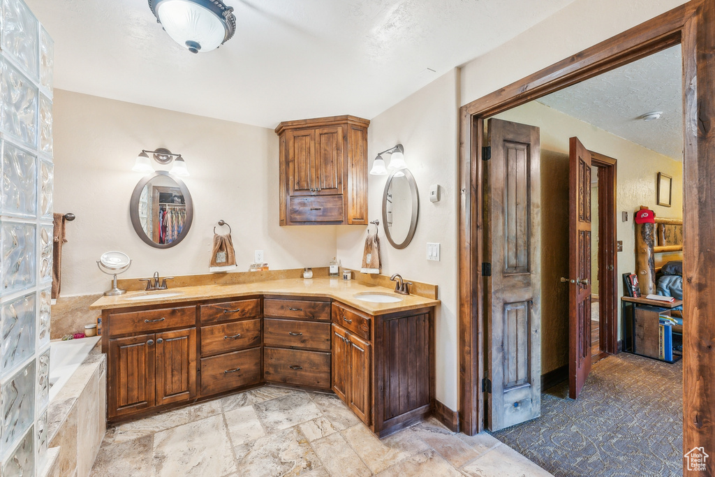 Bathroom with tile floors, a washtub, and double vanity