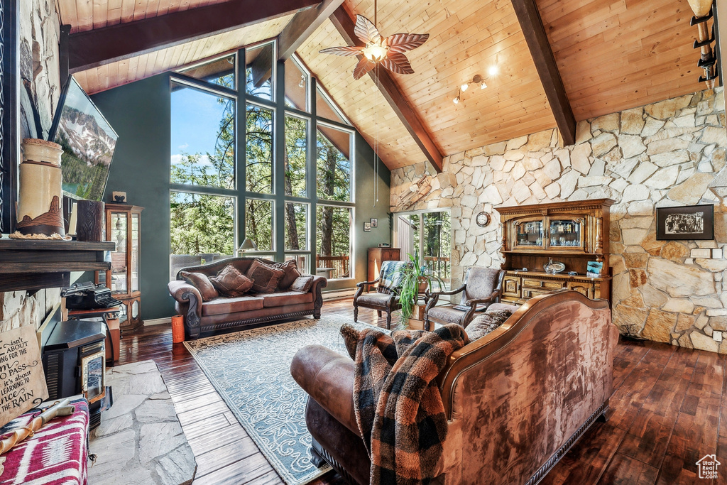 Living room with beam ceiling, wood ceiling, a wood stove, high vaulted ceiling, and hardwood / wood-style flooring