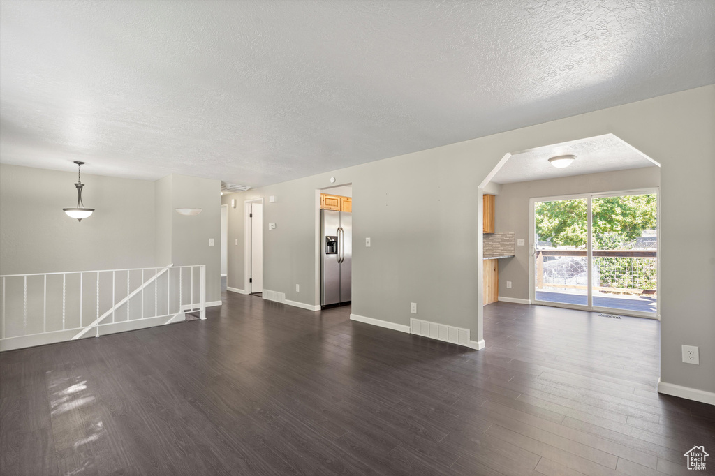 Interior space with dark hardwood / wood-style floors and a textured ceiling