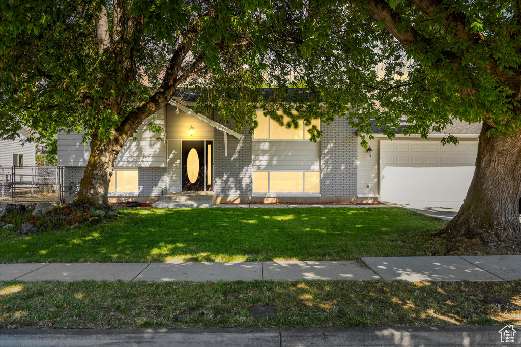 View of front of home with a garage and a front lawn