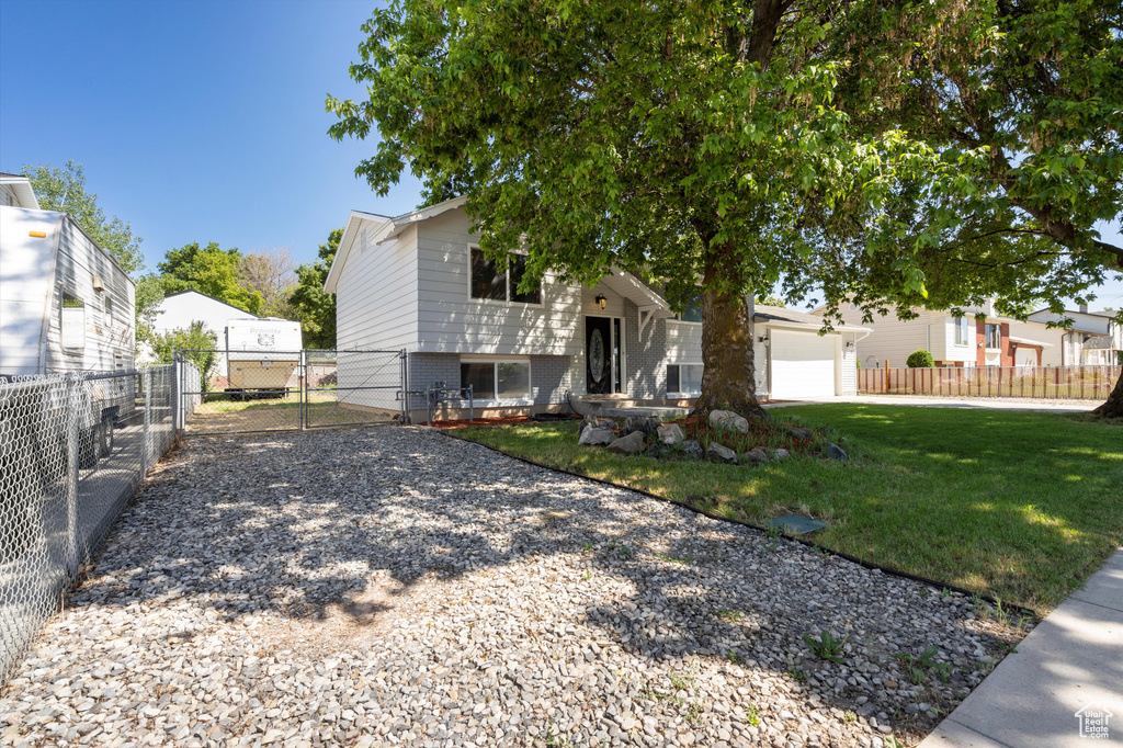 View of front of property featuring a garage and a front yard