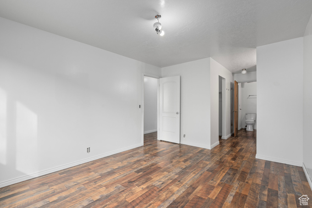 Spare room with a textured ceiling and dark hardwood / wood-style floors