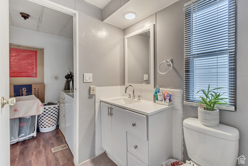 Bathroom with hardwood / wood-style floors, toilet, and vanity