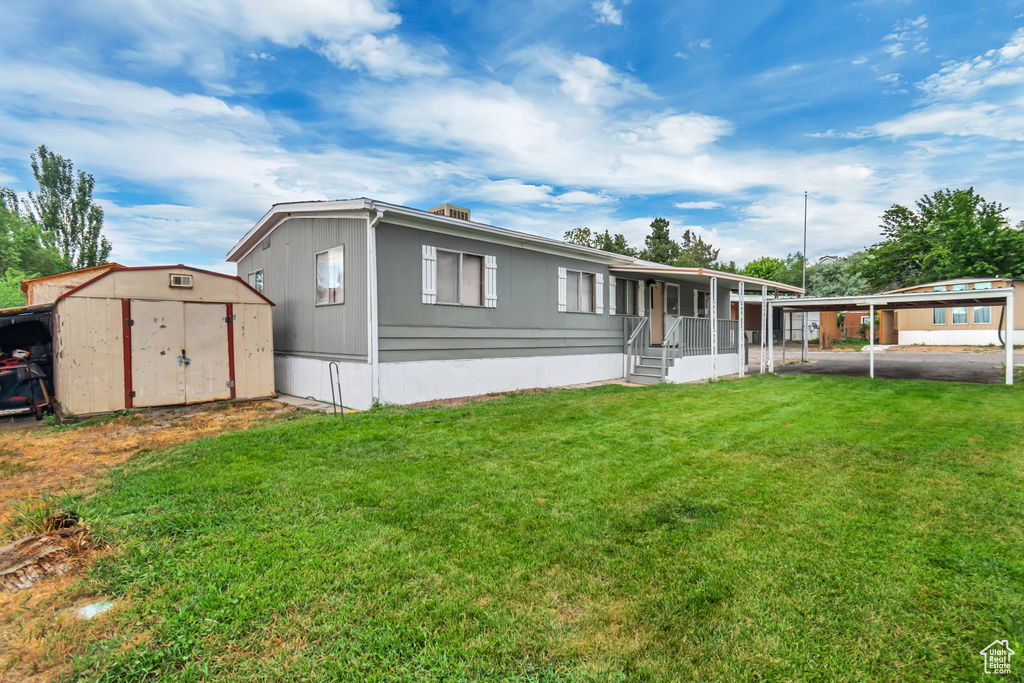 Exterior space with a carport, a shed, and a front yard