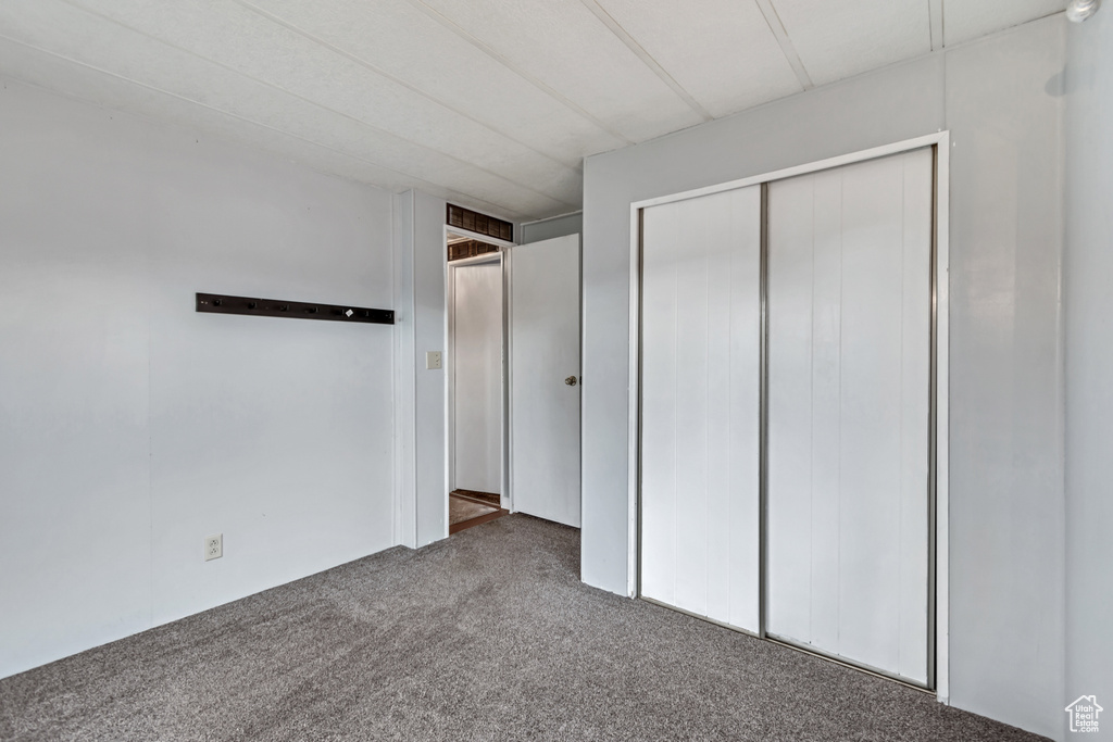 Unfurnished bedroom with carpet and a closet