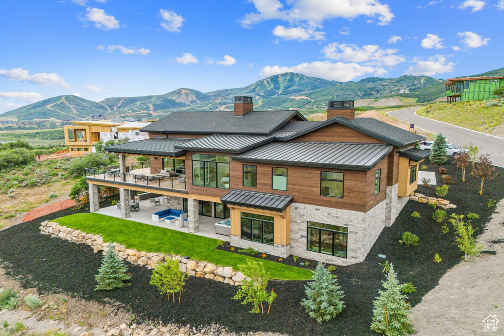 Rear view of house featuring a mountain view and a patio