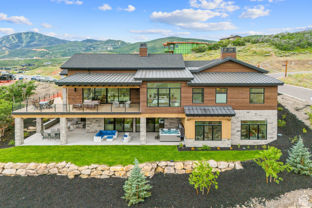 Rear view of house featuring outdoor lounge area, a patio, and a mountain view