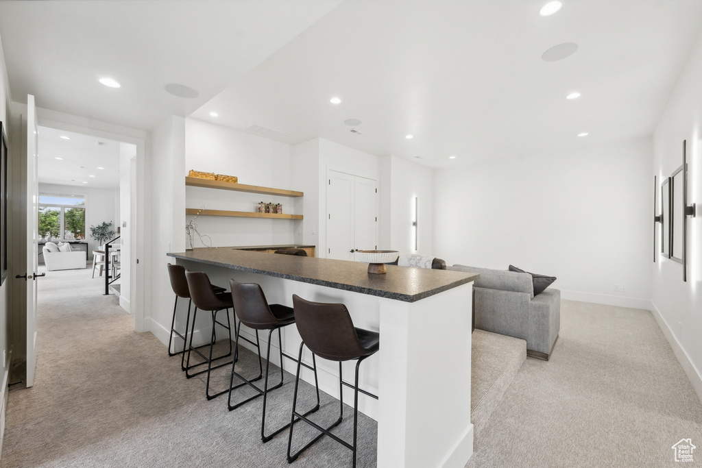 Kitchen with light carpet and a kitchen bar