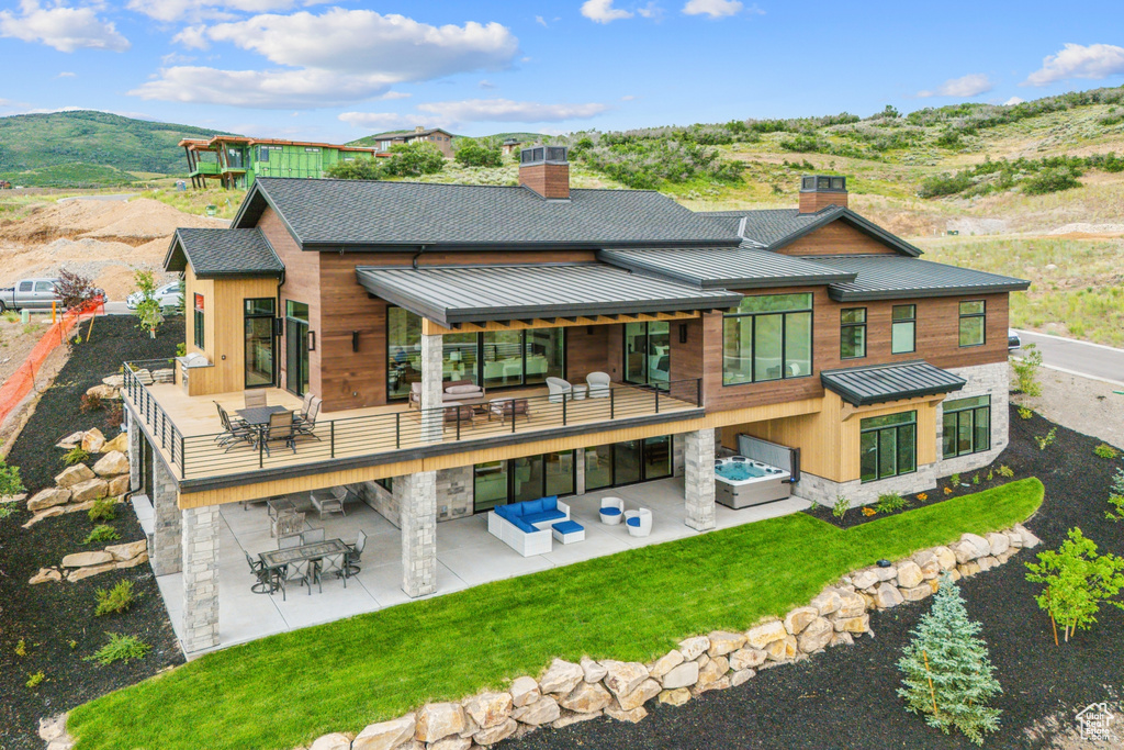 Back of property with a patio, a mountain view, and an outdoor hangout area